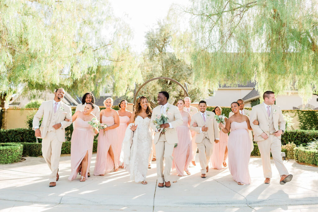 Bridal party celebrates with bride and groom at rustic wedding.