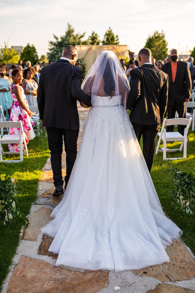 Bride walking down the isle of formal outdoor wedding in Arkansas. 