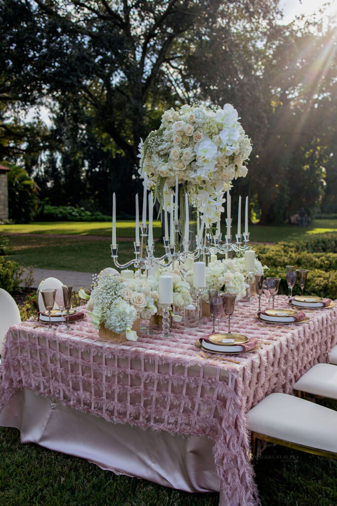 White and pastel floral arrangements for blooming spring wedding themed tablescape.