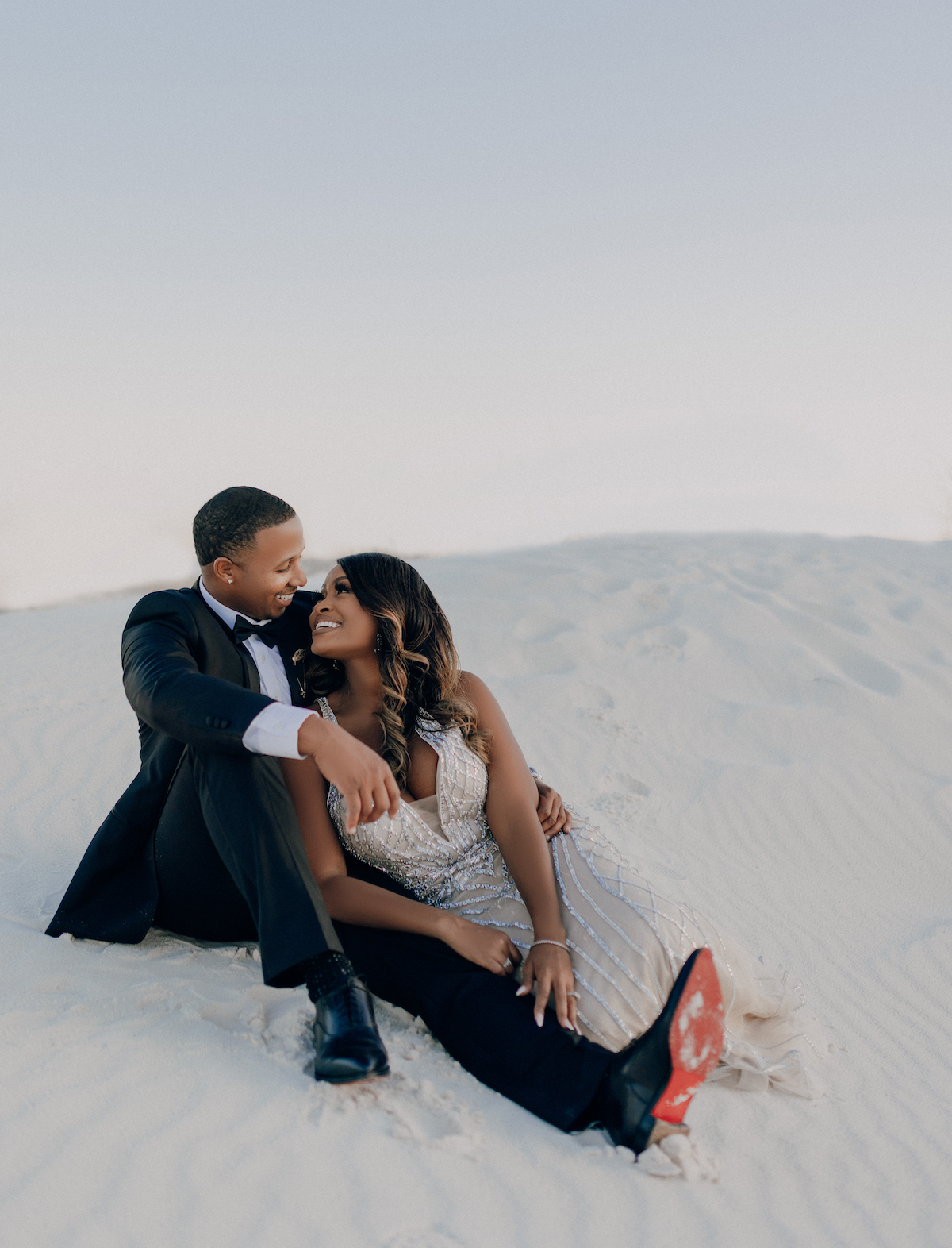 Engagement Session in White Sands New Mexico; couple sitting in the desert