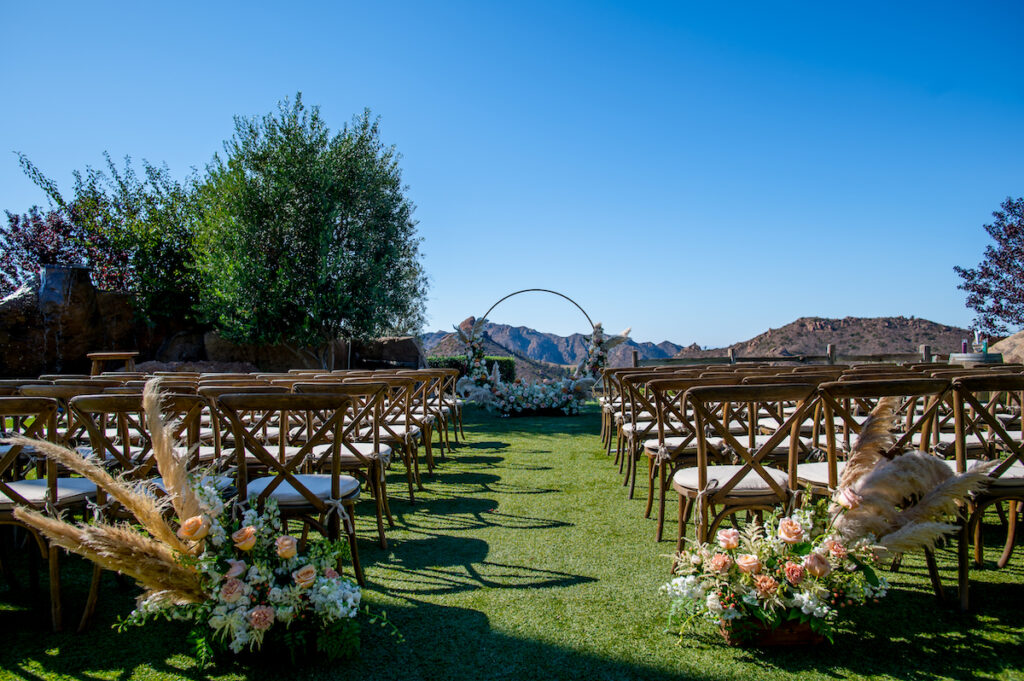 This hilltop vineyard wedding in Malibu is everything sweet with a sunset-inspired color story, an outdoor ceremony, and two glam dresses!