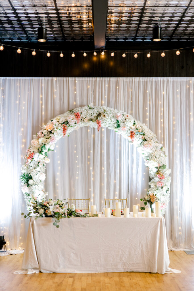 This waterfront wedding at the Tyee Yacht Club in Seattle, WA, features soft pink blooms, pops of red, and a bilingual English/Spanish ceremony.