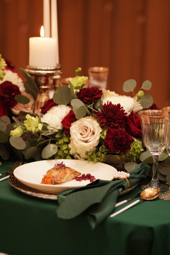 L Prestigious Events LLC crafted a breathtaking winter tablescape with emerald green hues, opulent gold accents, and romantic candles. (Featuring florals by fellow coterie member HTTS Floral and Event Design!).