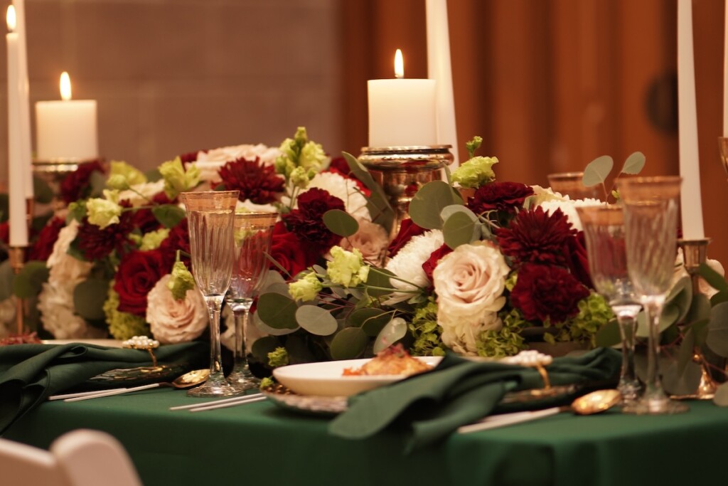 L Prestigious Events LLC crafted a breathtaking winter tablescape with emerald green hues, opulent gold accents, and romantic candles. (Featuring florals by fellow coterie member HTTS Floral and Event Design!).